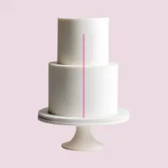 Un gâteau blanc à deux étages, orné d'une ligne rose verticale, est présenté sur un présentoir.