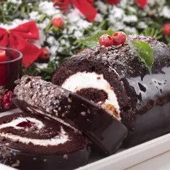 Bûche de Noël au chocolat, garnie de crème et de confiture. Parfait pour savoir avec quoi recouvrir une bûche de noël.