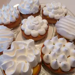 Plateau de tartelettes garnies de crème citronnée et surmontées de meringue italienne, une œuvre de conservation gourmande.
