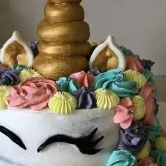 Un gâteau licorne facile sans pâte à sucre, décoré de crème colorée et d'une corne dorée. Parfait pour une fête magique !