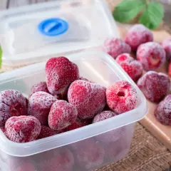 Des fraises congelées dans une boîte, prêtes pour l'hiver. Oui, on peut congeler un fraisier pour en profiter plus tard.