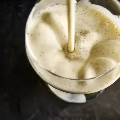 Crème vanillée versée dans un verre, évoquant la différence entre crème anglaise et pâtissière.