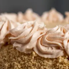 Gâteau recouvert de miettes et décoré de volutes de crème rose pâle. Une décoration gateau facile et élégante.