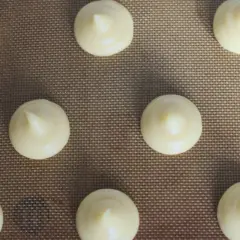 Chouquettes prêtes à cuire sur une plaque. Pour bien conserver des chouquettes, il faut les laisser refroidir complètement avant de les stocker.