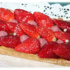 Tarte rectangulaire garnie de fraises fraîches et de petites boules roses. Un délice fruité, un vrai curd fraise !