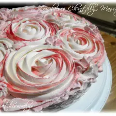Gâteau orné de roses en chantilly mascarpone, avec des touches de framboise pour une déco gourmande.