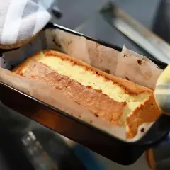 Un délicieux gâteau cake doré sort du four, prêt à être dégusté.