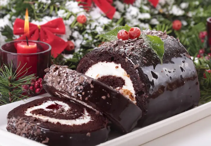 Bûche de Noël au chocolat, garnie de crème et de confiture. Parfait pour savoir avec quoi recouvrir une bûche de noël.