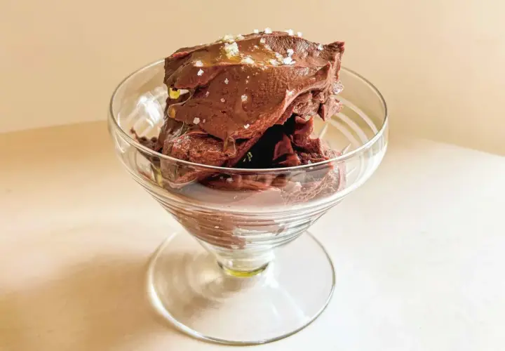 Glace au chocolat onctueuse, parsemée de sel, dans un verre à pied. Un délice de ganache coco.