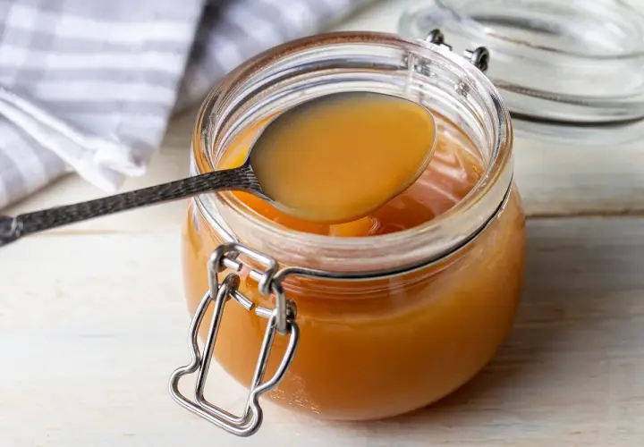 Une cuillère dégustant la confiture de lait maison, prête à être dégustée. Une recette simple et gourmande.