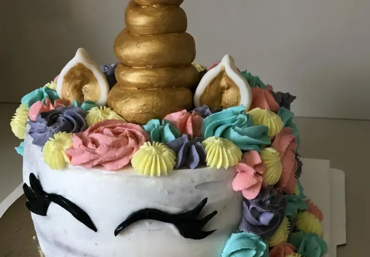 Un gâteau licorne facile sans pâte à sucre, décoré de crème colorée et d'une corne dorée. Parfait pour une fête magique !