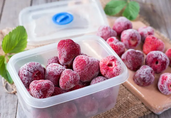 Des fraises congelées dans une boîte, prêtes pour l'hiver. Oui, on peut congeler un fraisier pour en profiter plus tard.