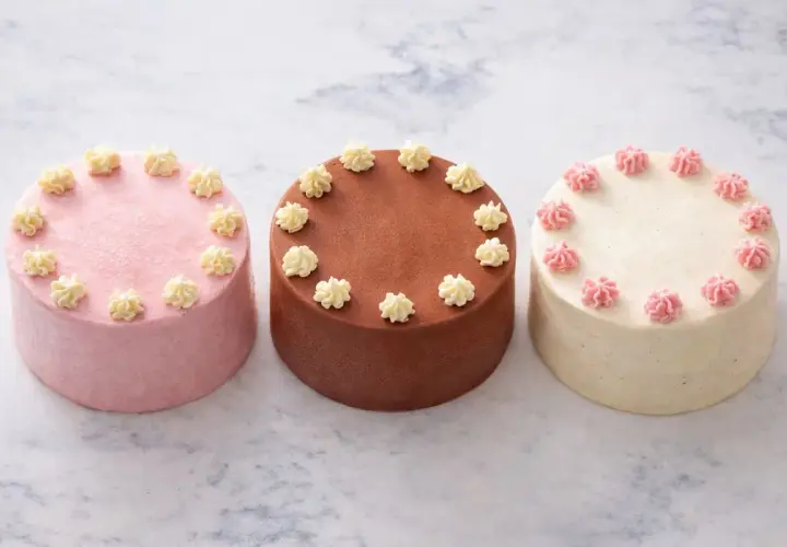 Trois petits gâteaux, une recette bento cake : rose, chocolat et vanille, décorés de crème.