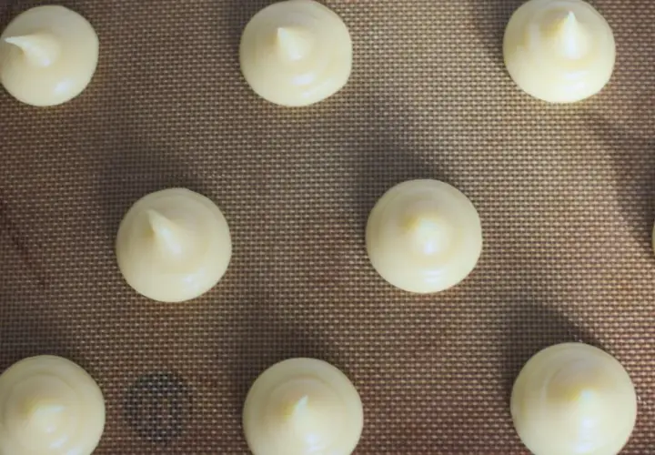 Chouquettes prêtes à cuire sur une plaque. Pour bien conserver des chouquettes, il faut les laisser refroidir complètement avant de les stocker.