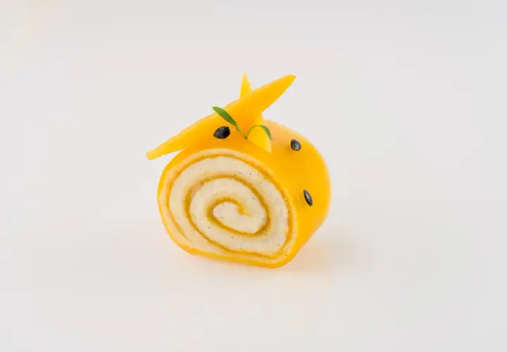 Un adorable petit roulé jaune, décoré comme un animal, montre ce que faire avec de la purée de fruits.