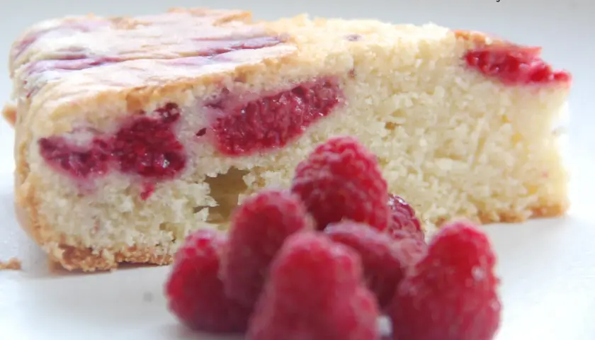 Tranche de molly cake framboise, moelleuse et généreuse, parsemée de fruits rouges. Un délice !