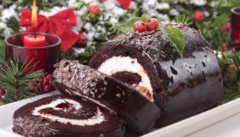 Bûche de Noël au chocolat, garnie de crème et de confiture. Parfait pour savoir avec quoi recouvrir une bûche de noël.