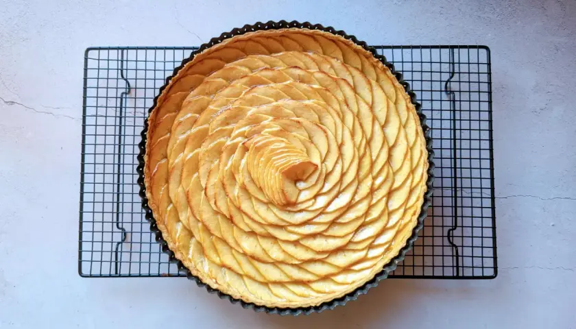 Tarte aux pommes magnifiquement décorée de fines tranches de pommes disposées en spirale. Une œuvre d'art culinaire pour la conservation.