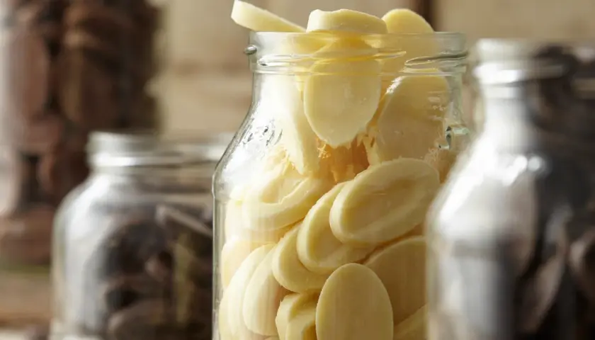 Des éclats de chocolat blanc dans un bocal, prêts pour la conservation. Le chocolat maison est un délice.
