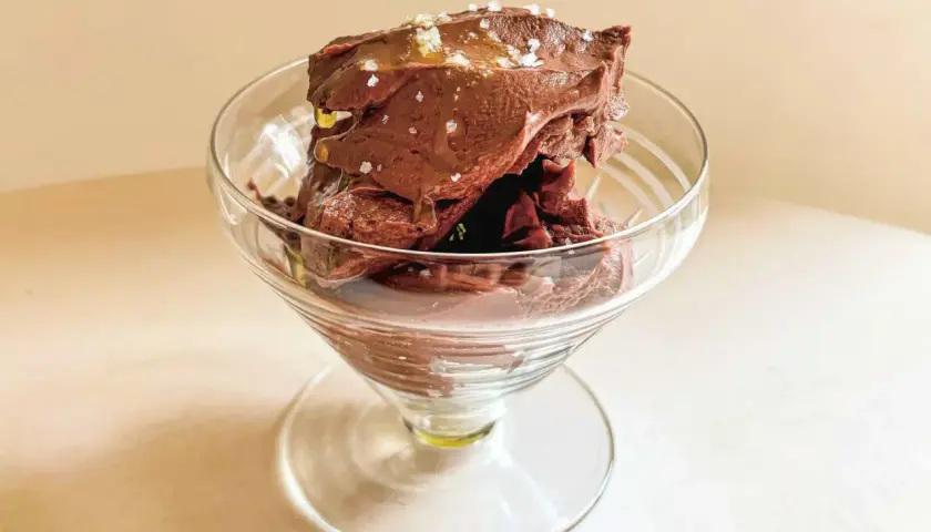 Glace au chocolat onctueuse, parsemée de sel, dans un verre à pied. Un délice de ganache coco.