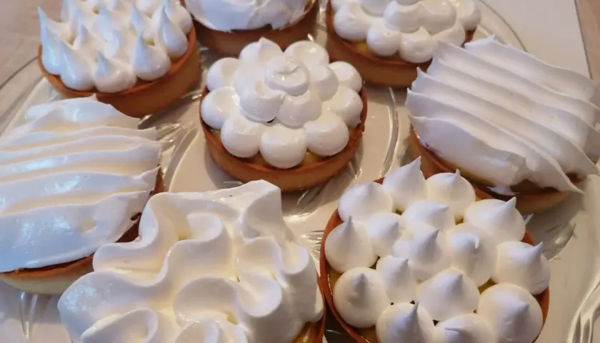 Plateau de tartelettes garnies de crème citronnée et surmontées de meringue italienne, une œuvre de conservation gourmande.