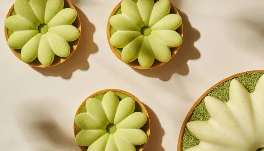 Trois tartelettes vertes en forme de fleur, une autre blanche à la vanille. La cuisson du sucre a donné des desserts délicats.