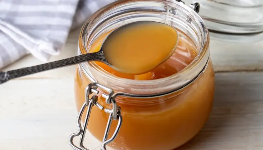 Une cuillère dégustant la confiture de lait maison, prête à être dégustée. Une recette simple et gourmande.