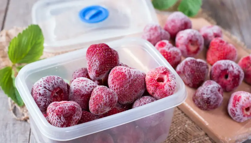 Des fraises congelées dans une boîte, prêtes pour l'hiver. Oui, on peut congeler un fraisier pour en profiter plus tard.