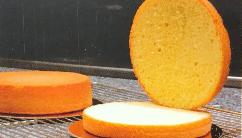 Trois disques de génoise dorée, prêts à imbiber une génoise avec du lait pour un dessert moelleux.