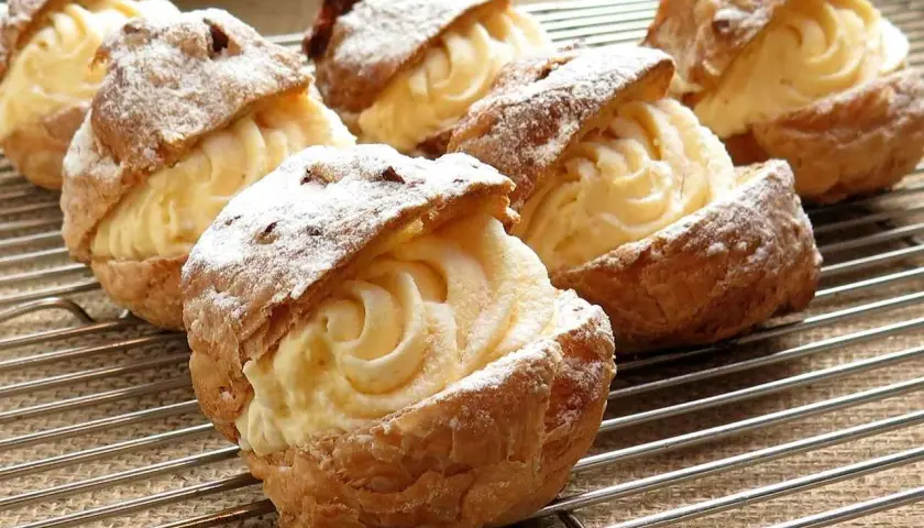 Choux garnis d'une délicieuse crème pâtissière sans œuf, saupoudrés de sucre glace. Un délice léger et aérien.