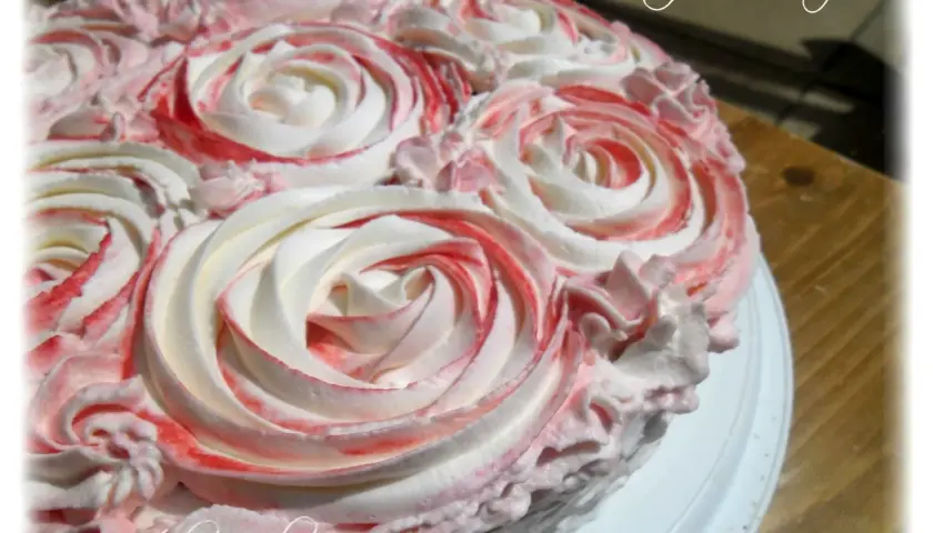 Gâteau orné de roses en chantilly mascarpone, avec des touches de framboise pour une déco gourmande.