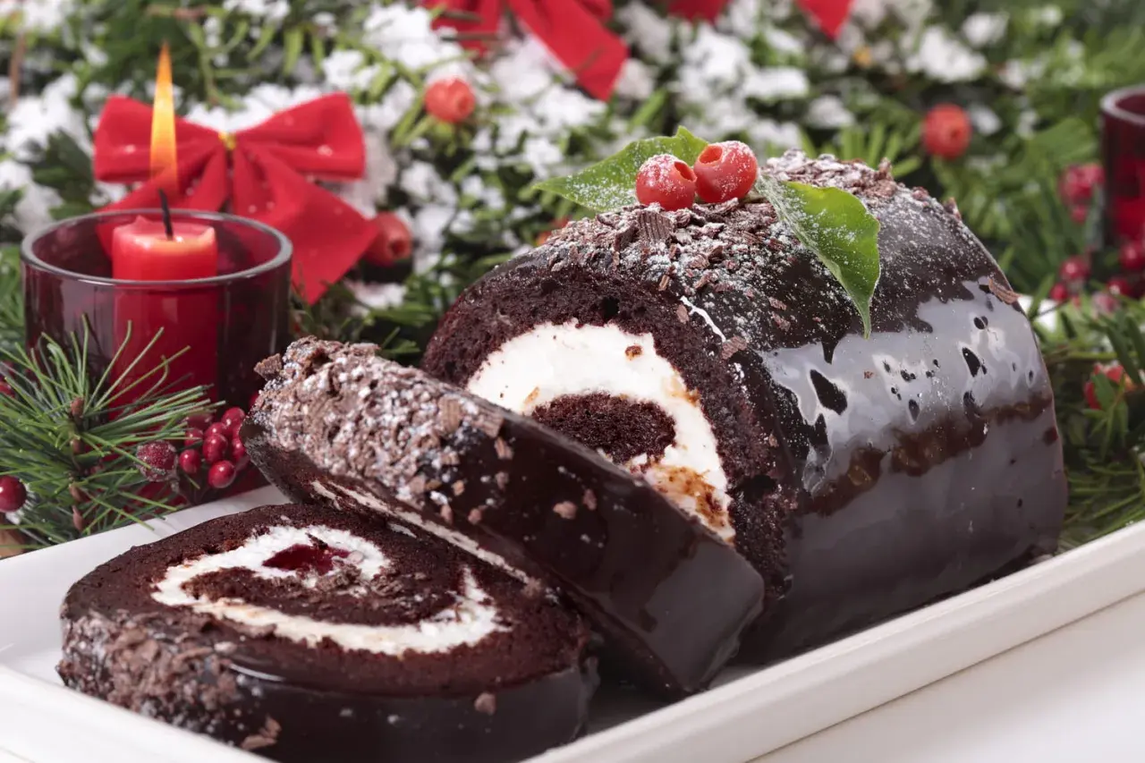 Bûche de Noël au chocolat, garnie de crème et de confiture. Parfait pour savoir avec quoi recouvrir une bûche de noël.