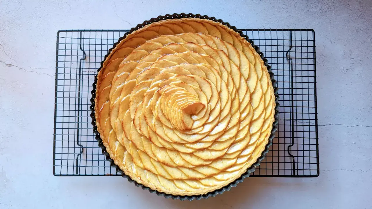 Tarte aux pommes magnifiquement décorée de fines tranches de pommes disposées en spirale. Une œuvre d'art culinaire pour la conservation.