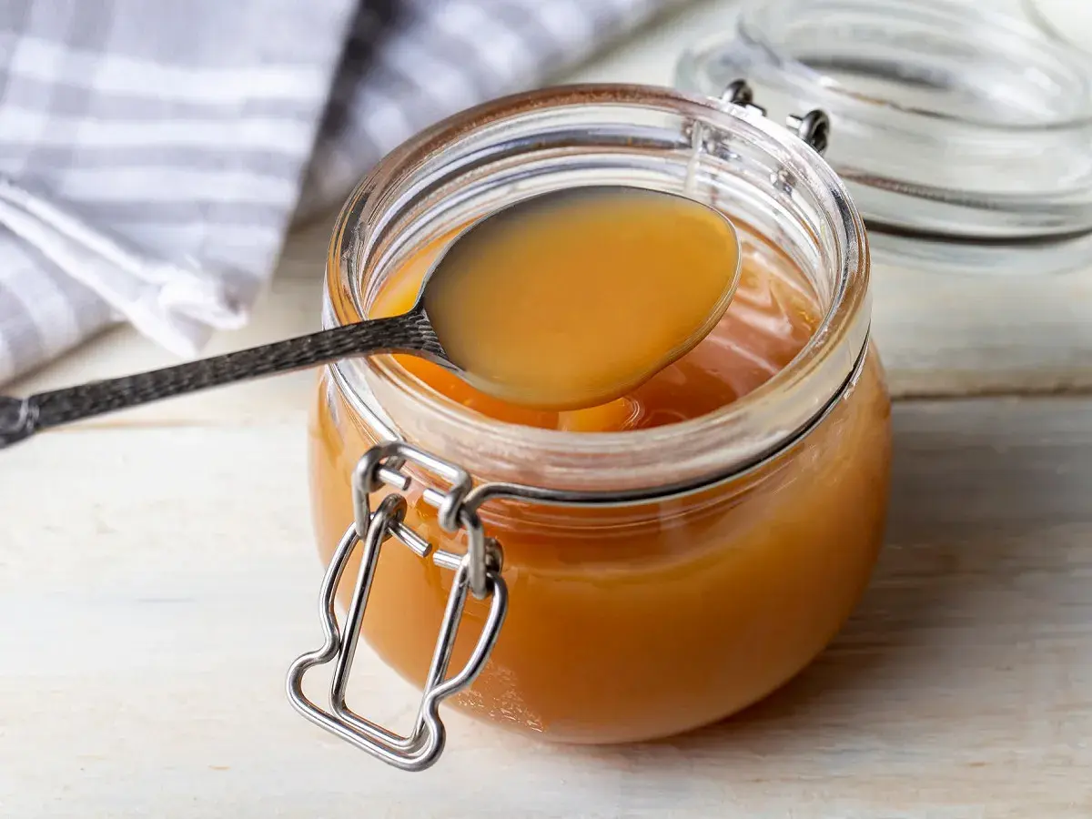 Une cuillère dégustant la confiture de lait maison, prête à être dégustée. Une recette simple et gourmande.