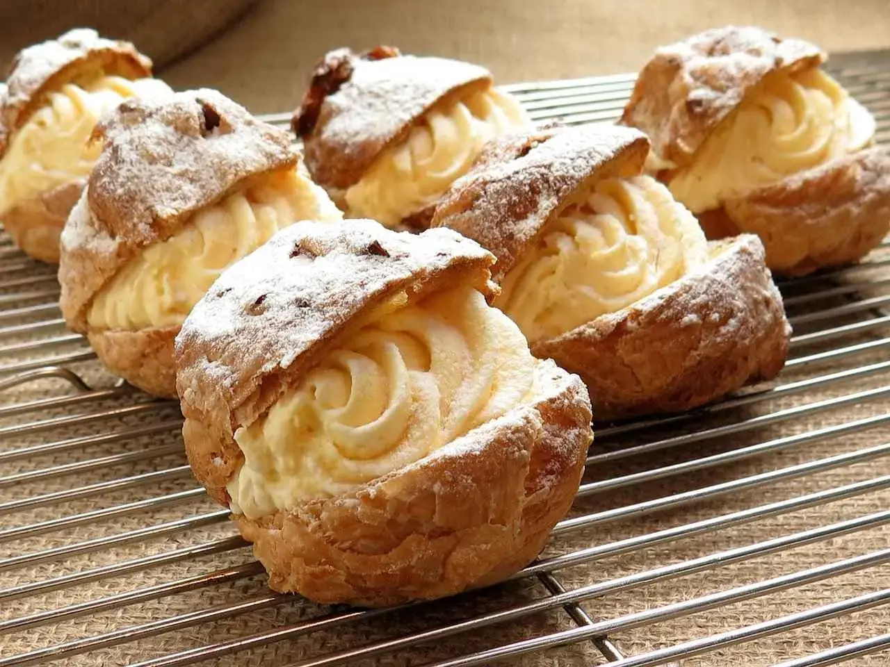Choux garnis d'une délicieuse crème pâtissière sans œuf, saupoudrés de sucre glace. Un délice léger et aérien.