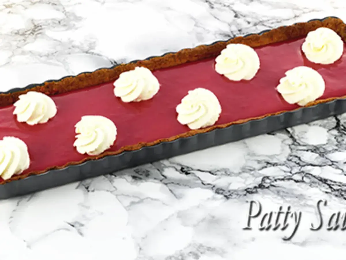 Tarte rectangulaire au curd framboise, garnie de touches de crème fouettée. Un délice fruité et gourmand.