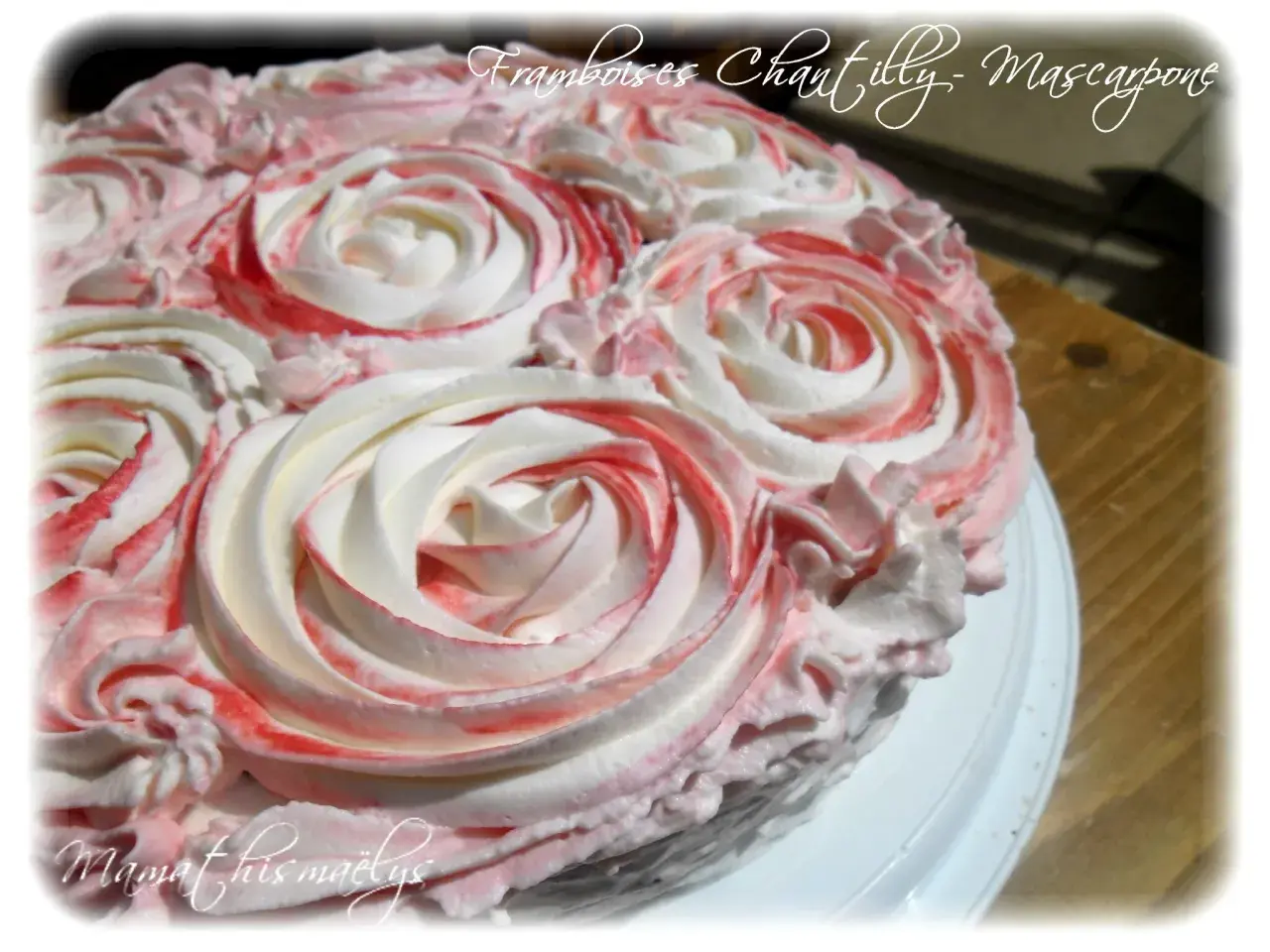 Gâteau orné de roses en chantilly mascarpone, avec des touches de framboise pour une déco gourmande.