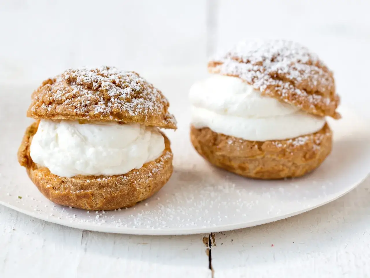 Deux choux garnis de crème, saupoudrés de sucre glace. Parfait pour savoir si peut on faire la pâte à choux la veille.