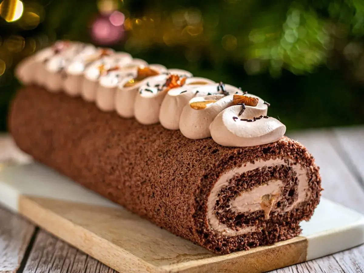 Bûche de Noël au chocolat, parfaite pour une recette à congeler. Décorée de crème chantilly et d'amandes.