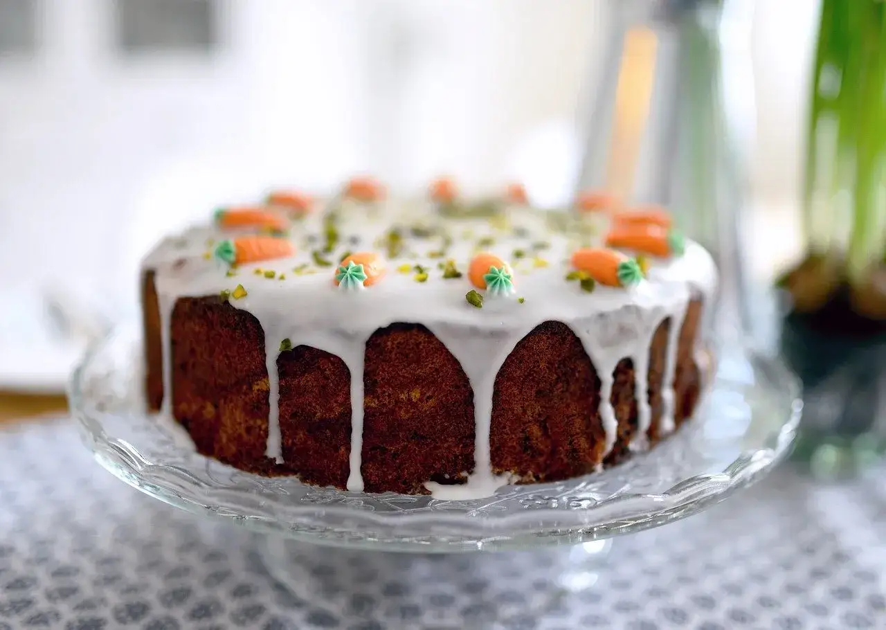Gâteau aux carottes avec glaçage blanc dégoulinant, décoré de petites carottes en sucre. Le meilleur glaçage pour décorer gâteau, simple et festif.