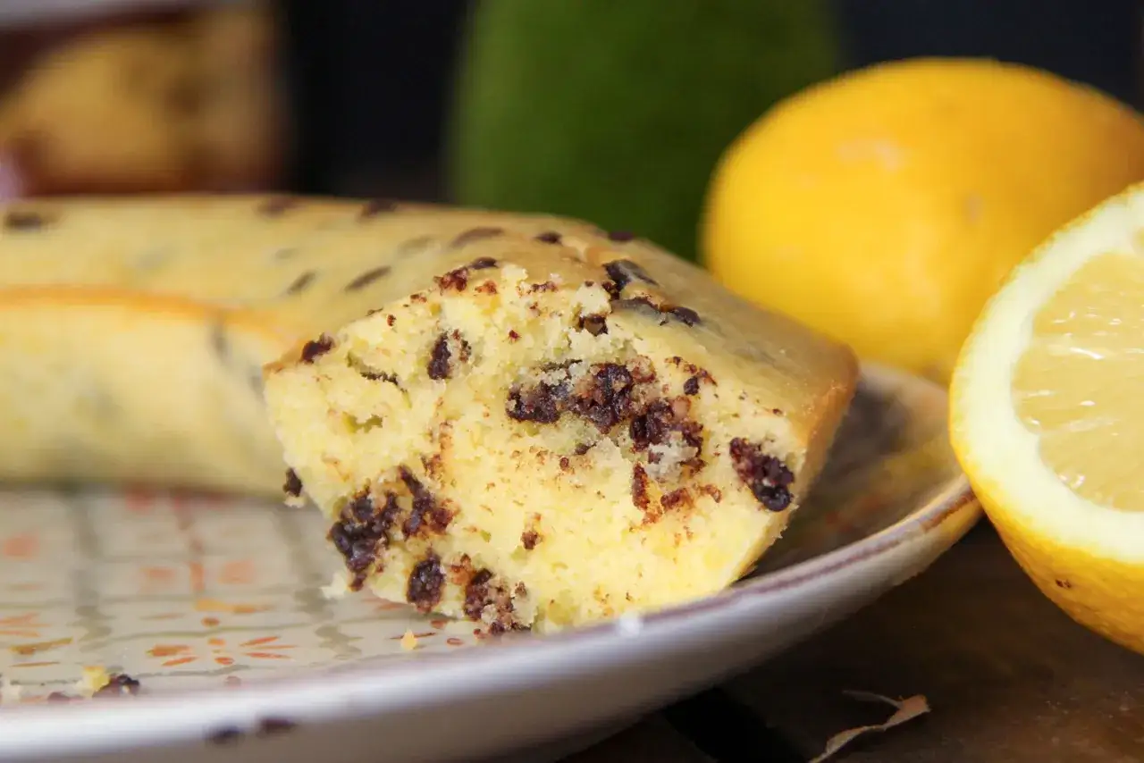 Un délicieux gâteau cake aux pépites de chocolat, prêt à être dégusté avec un citron frais.