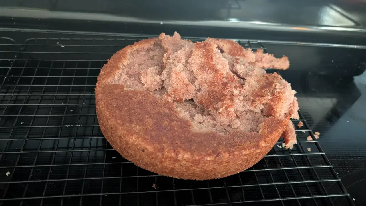 Un gâteau raté, tout émietté, repose sur une grille de refroidissement.