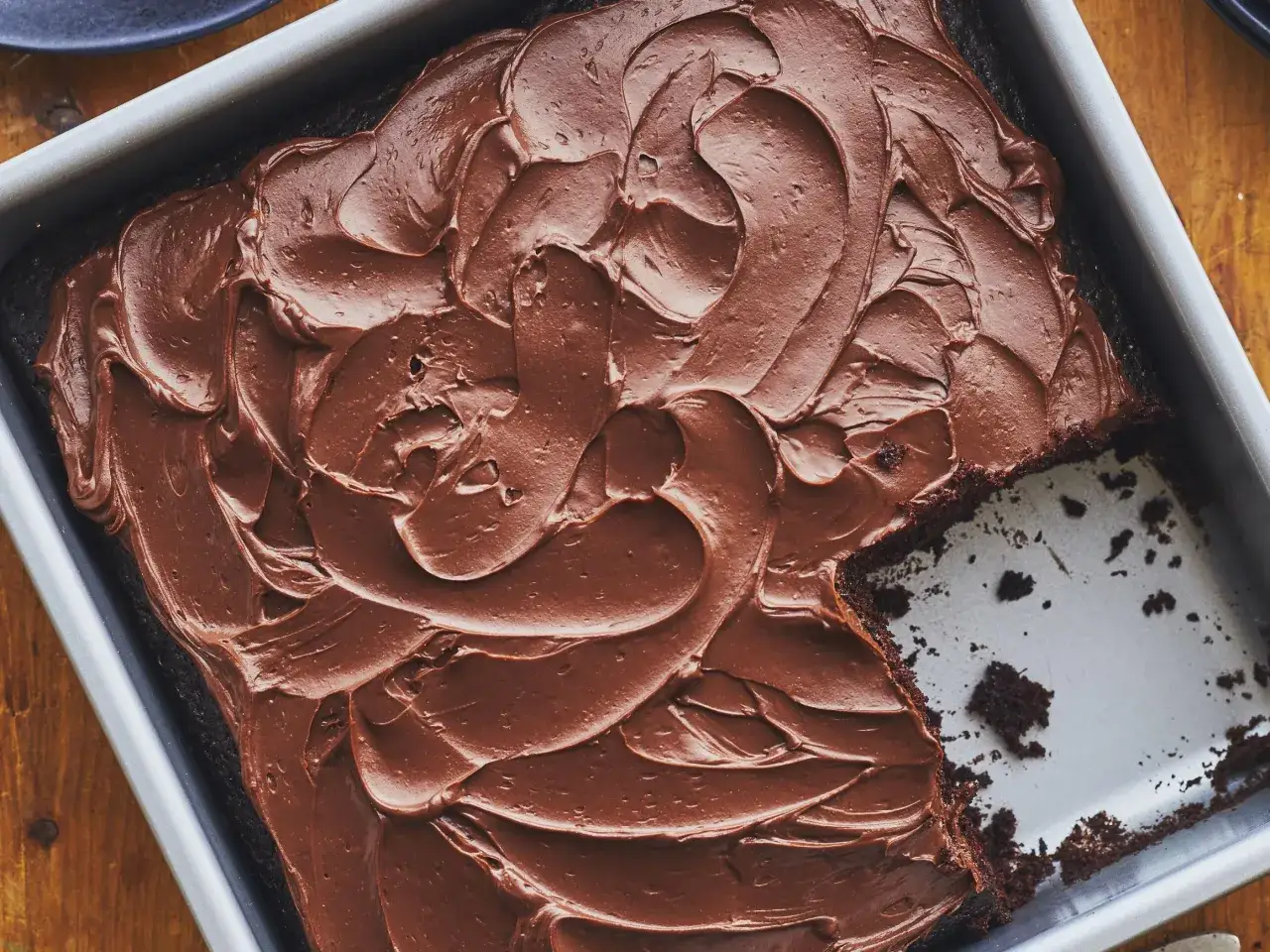 G&acirc;teau au cacao en poudre, tout juste sorti du four, avec un gla&ccedil;age au chocolat onctueux. Une part a &eacute;t&eacute; retir&eacute;e, r&eacute;v&eacute;lant la texture moelleuse.