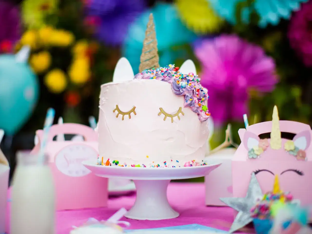 Gâteau licorne facile sans pâte à sucre, décoré de glaçage rose et violet, de vermicelles colorés et d'une corne dorée. Parfait pour une fête magique !