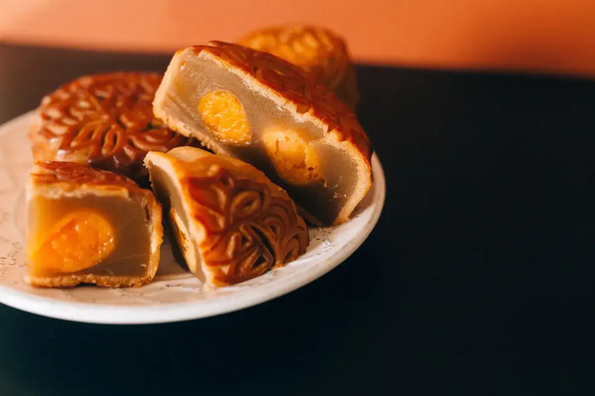 Gâteau de lune coupé, révélant sa garniture dorée. Une délicieuse recette de mooncake à partager.